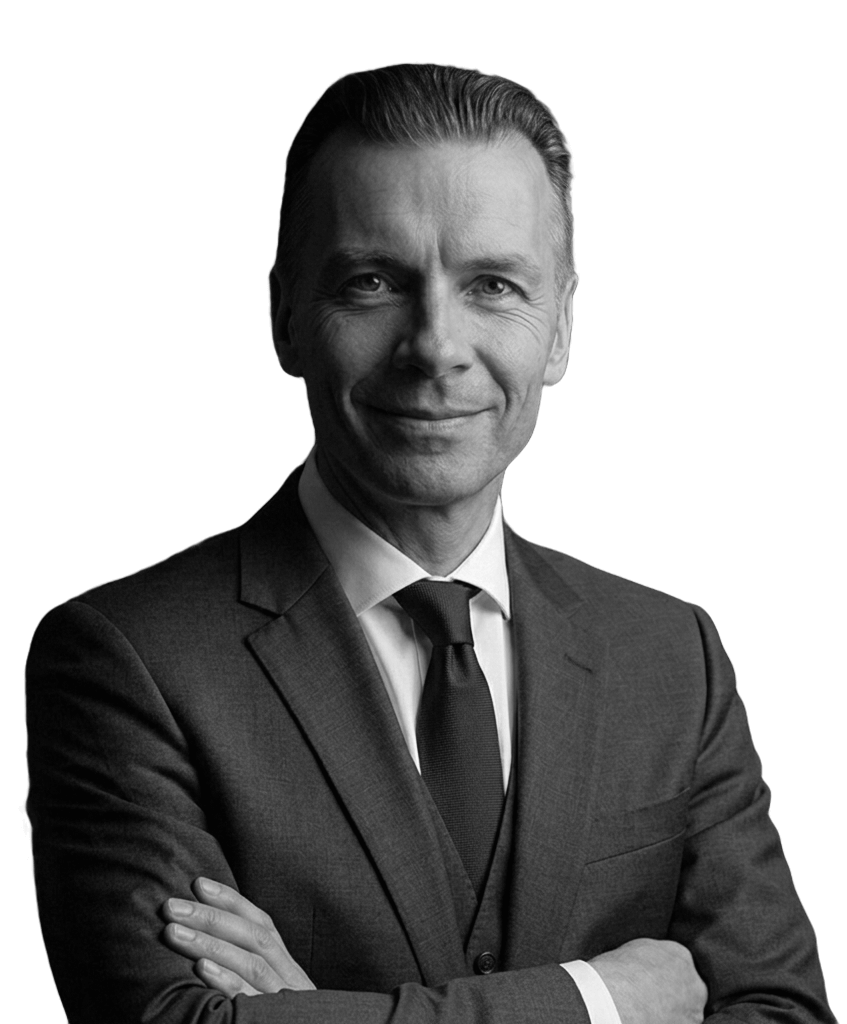 Black and white portrait of a confident middle-aged man in a suit and tie with arms crossed.